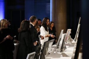 Guests review The Hellenic Initiative Silent Auction items on display.